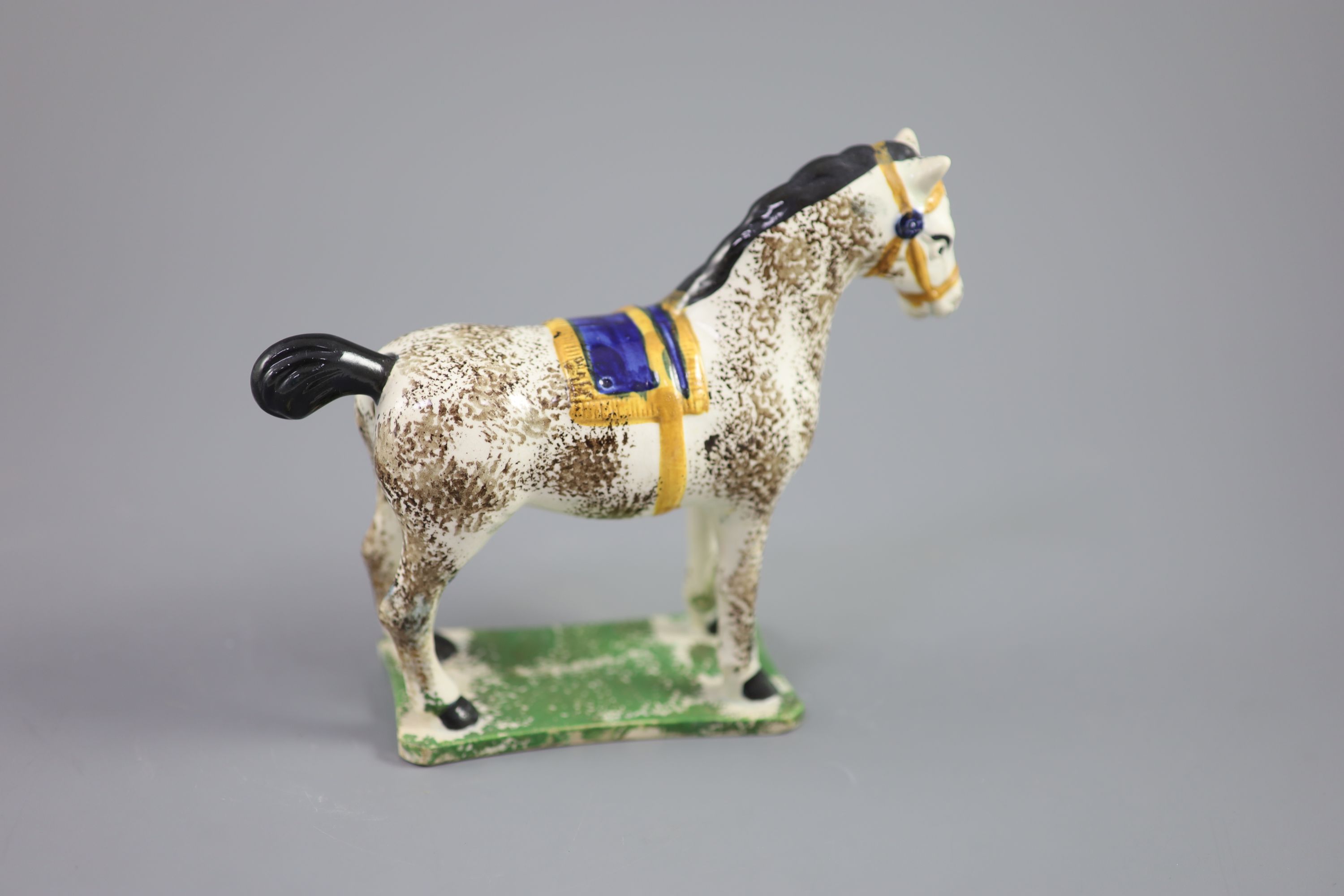 A North Country pearlware figure of a dapple horse with blue saddle, c.1800-20 14.5cm high